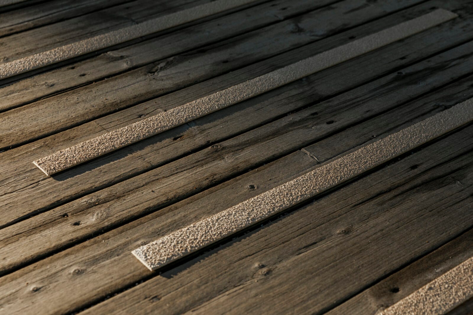 Beigea halkskyddslister på trätrall