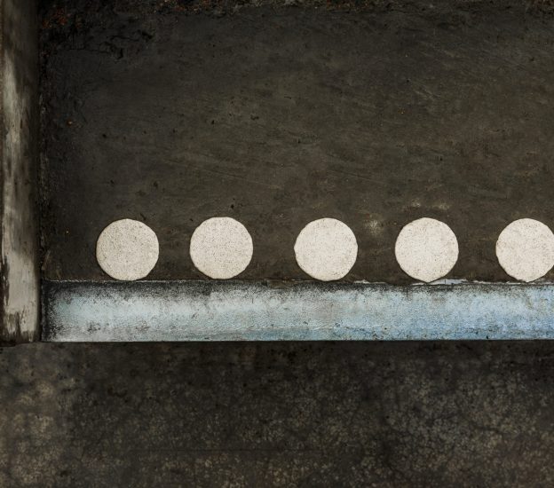 Vita kontrastmarkeringsprickar i termoplast på blöt betongtrappa